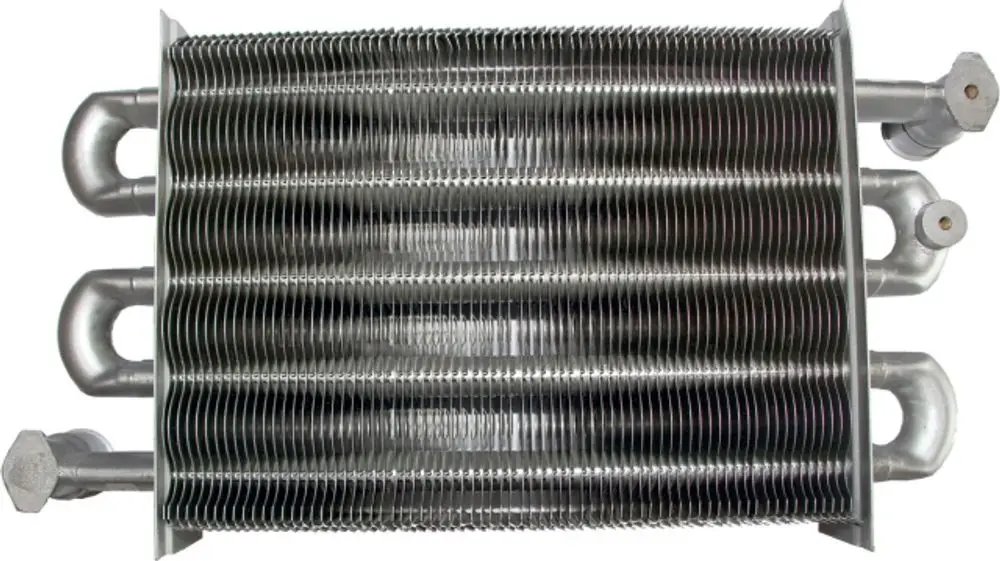Heizwasserwärmetauscher aus Metall mit mehreren Röhren und Anschlüssen, verwendet in Heizsystemen, sichtbar montiert, möglicherweise von der Marke Wolf.